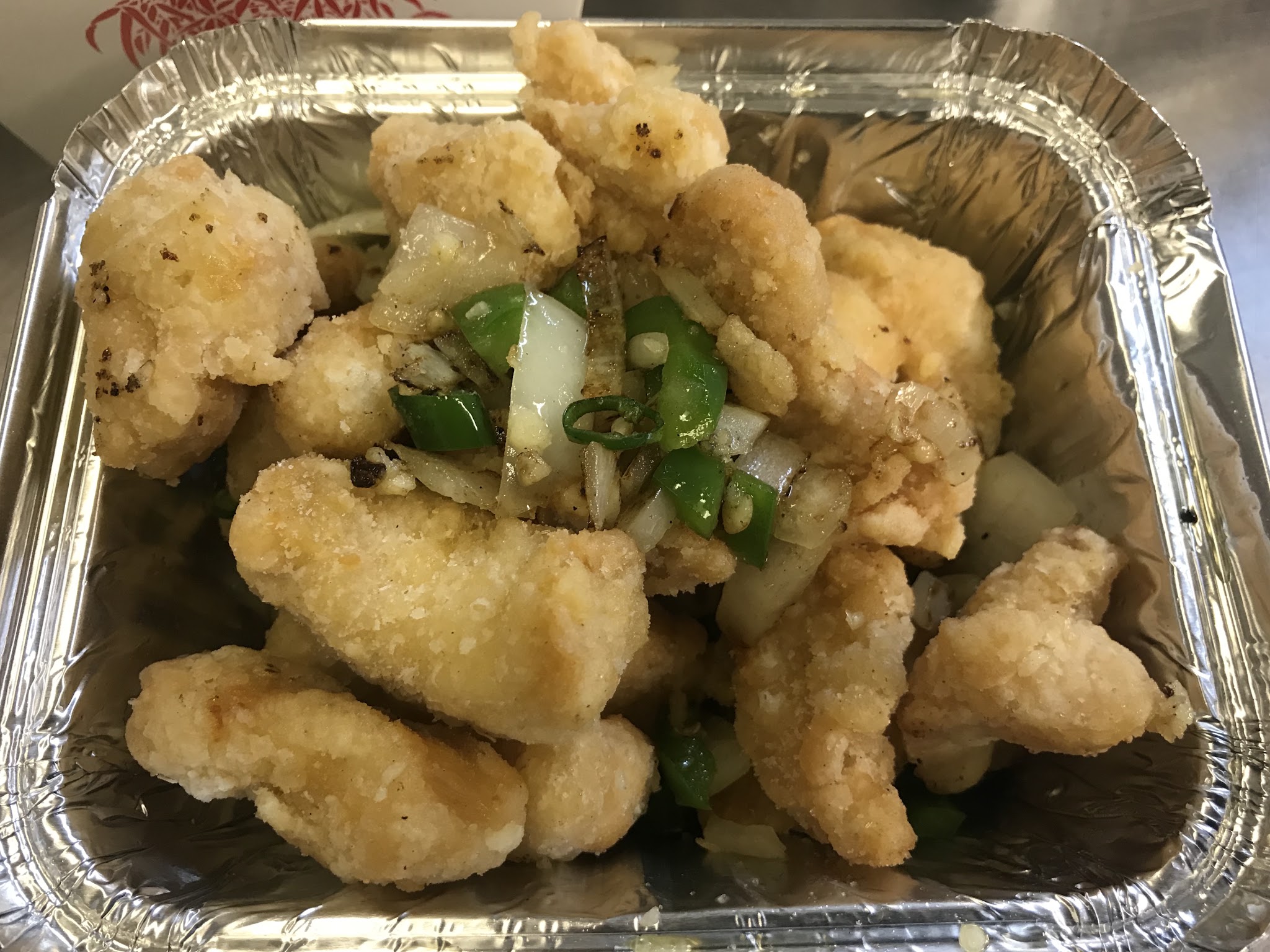 A takeaway dish with onions and peppers